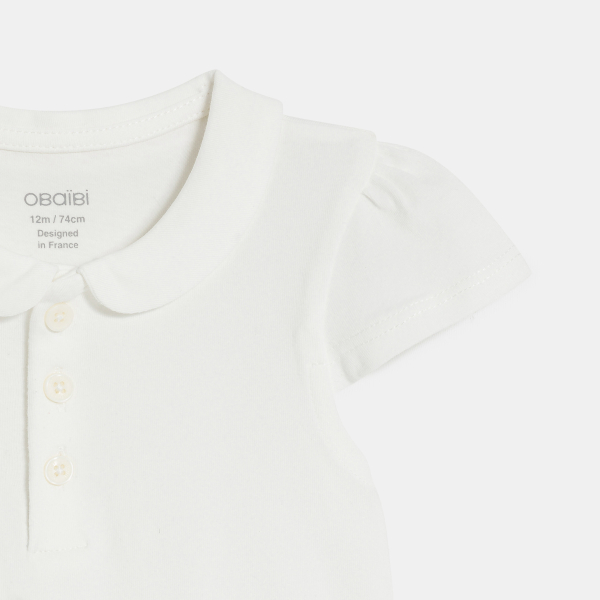 قميص بولو من القطن بياقة مستديرة، باللون الأبيض للفتيات الصغيرات. قميص بولو من القطن بياقة مستديرة، باللون الأبيض للفتيات الصغيرات.